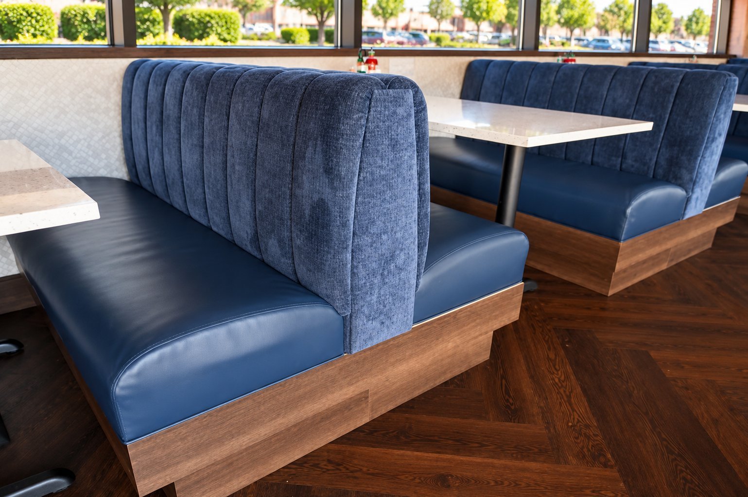 Navy blue channel-tufted vinyl booth with wood base