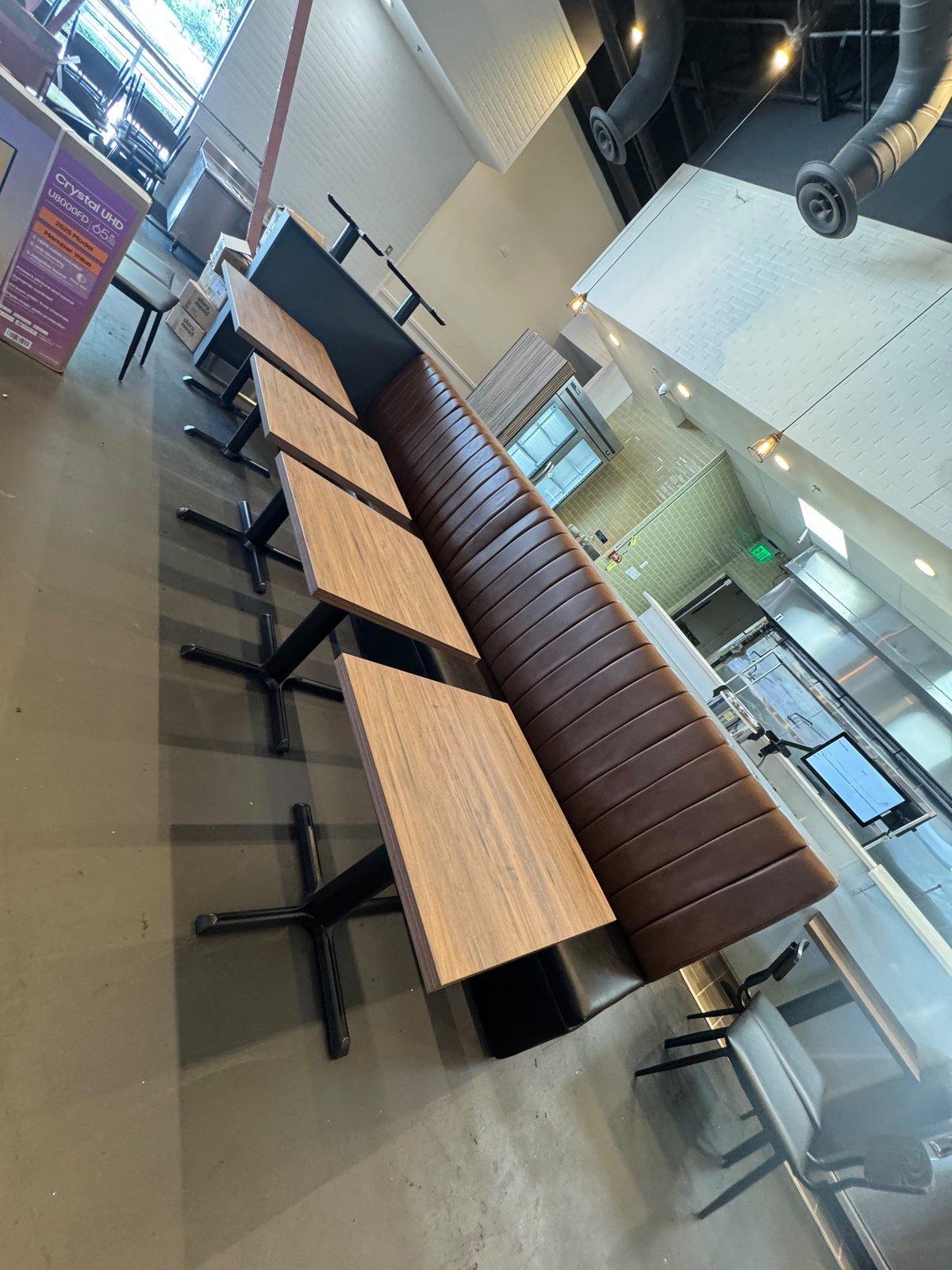Dark brown tufted banquette bench with floor-to-ceiling windows