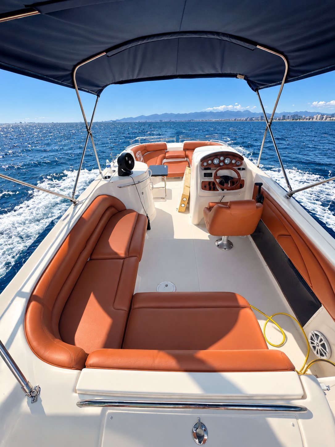 Cognac marine vinyl bench and helm seating under a bimini top